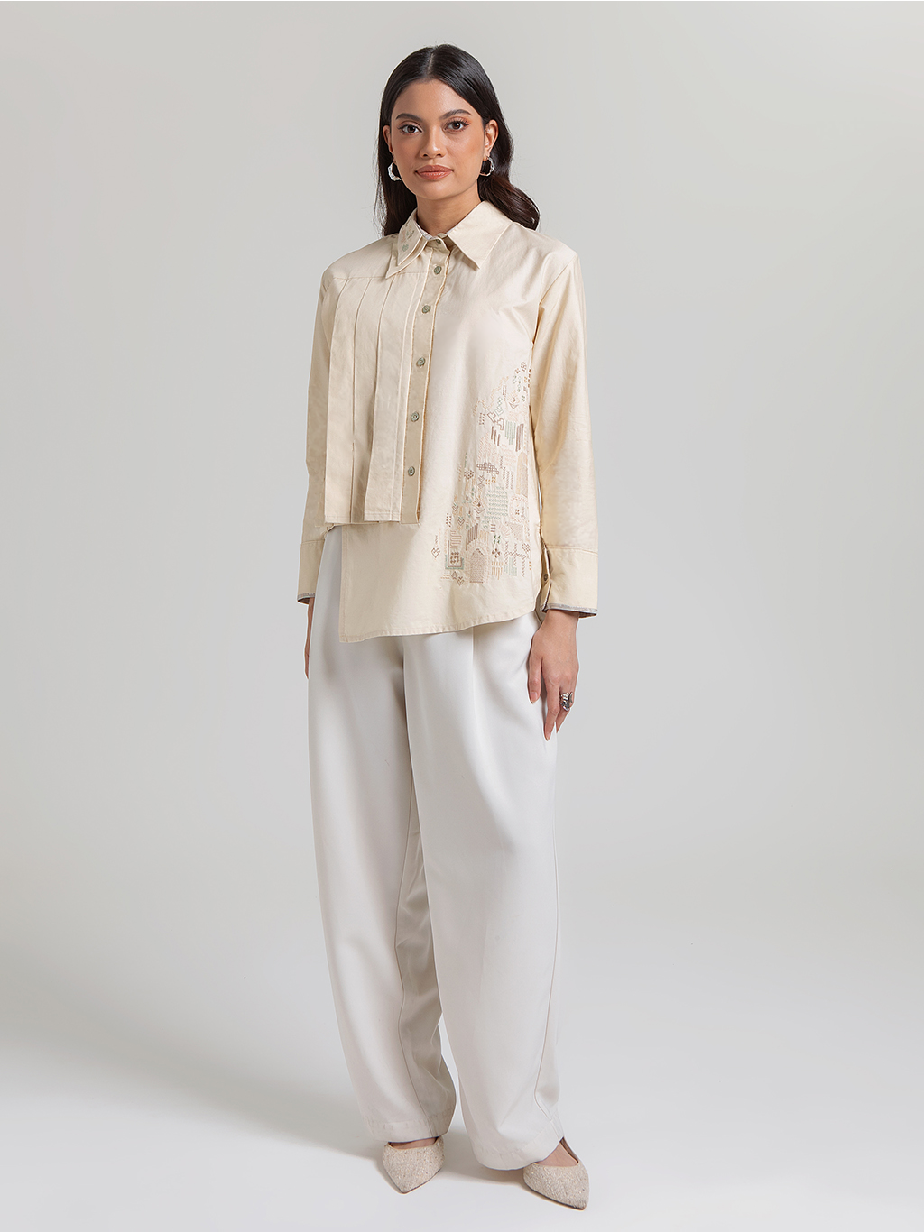 Diskon 15% atasan wanita lengan panjang premium berbahan 100% katun adem. Desain asimetris berlapis dengan detail lipit (pleats) dan aksen bordir yang elegan.