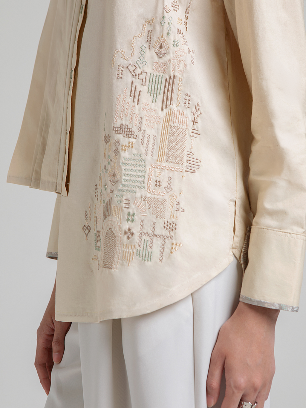 Diskon 15% atasan wanita lengan panjang premium berbahan 100% katun adem. Desain asimetris berlapis dengan detail lipit (pleats) dan aksen bordir yang elegan.